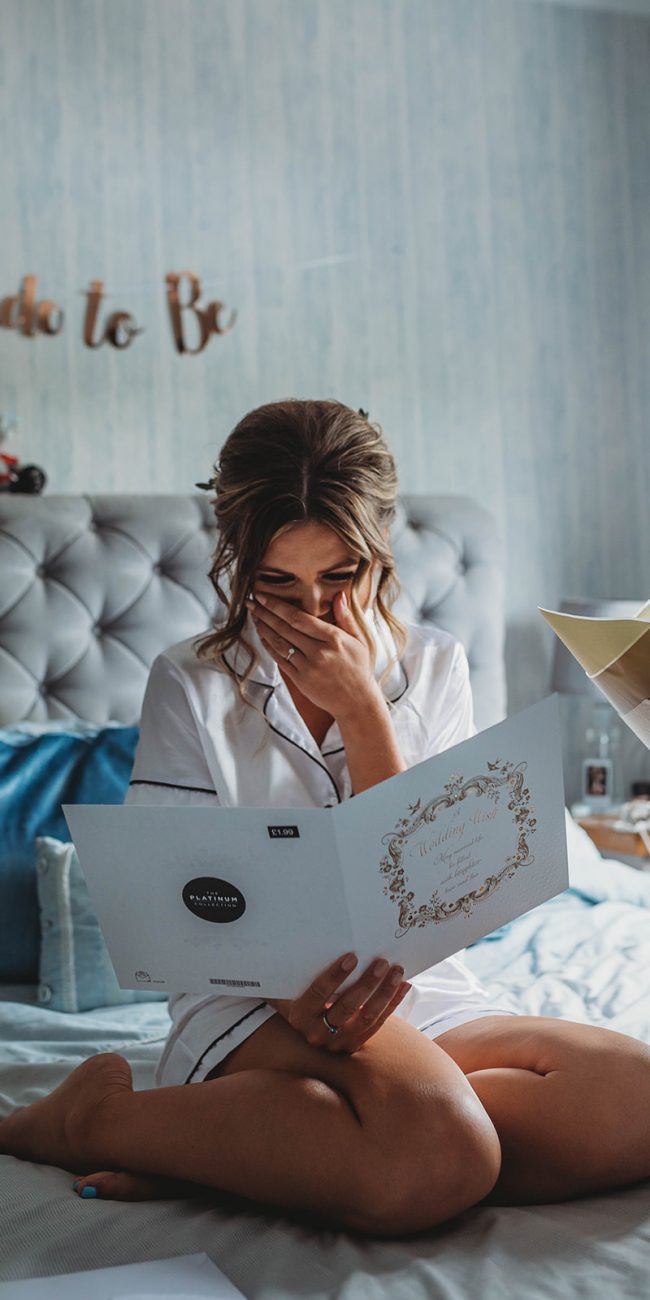 An emotional bride to be reading a card from her fiance on the morning of their wedding day