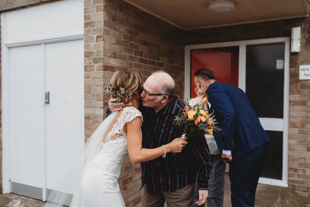 Bride + groom visiting family wearing their wedding attire that couldn't attend their wedding due to COVID restrictions