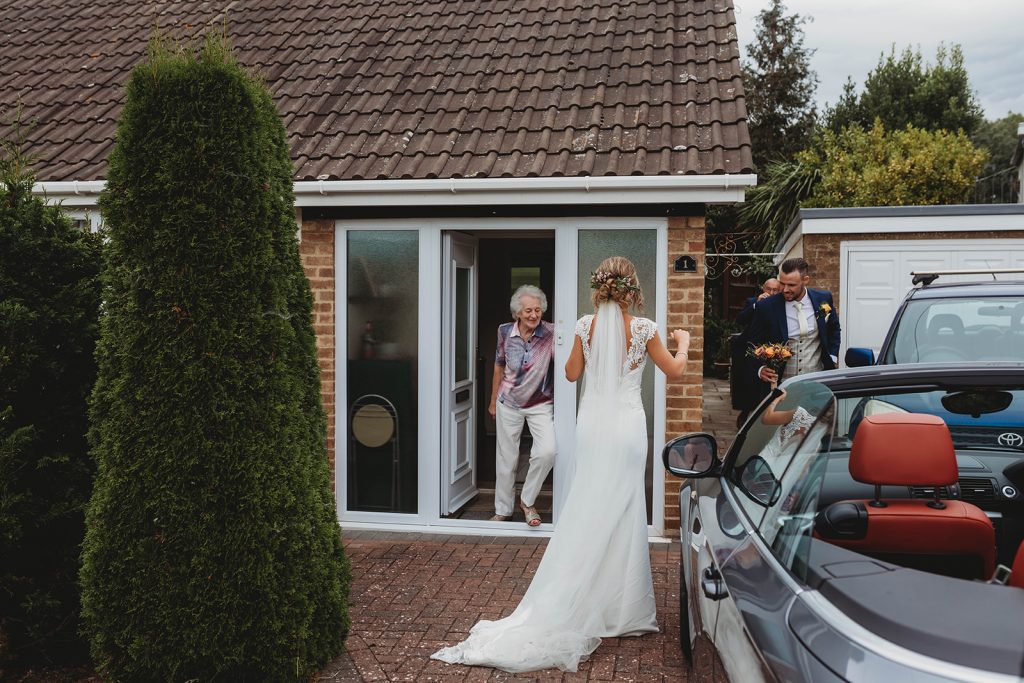 Bride + groom visiting family wearing their wedding attire that couldn't attend their wedding due to COVID restrictions