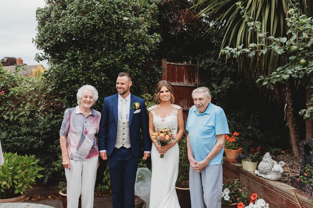 Bride + groom visiting family wearing their wedding attire that couldn't attend their wedding due to COVID restrictions