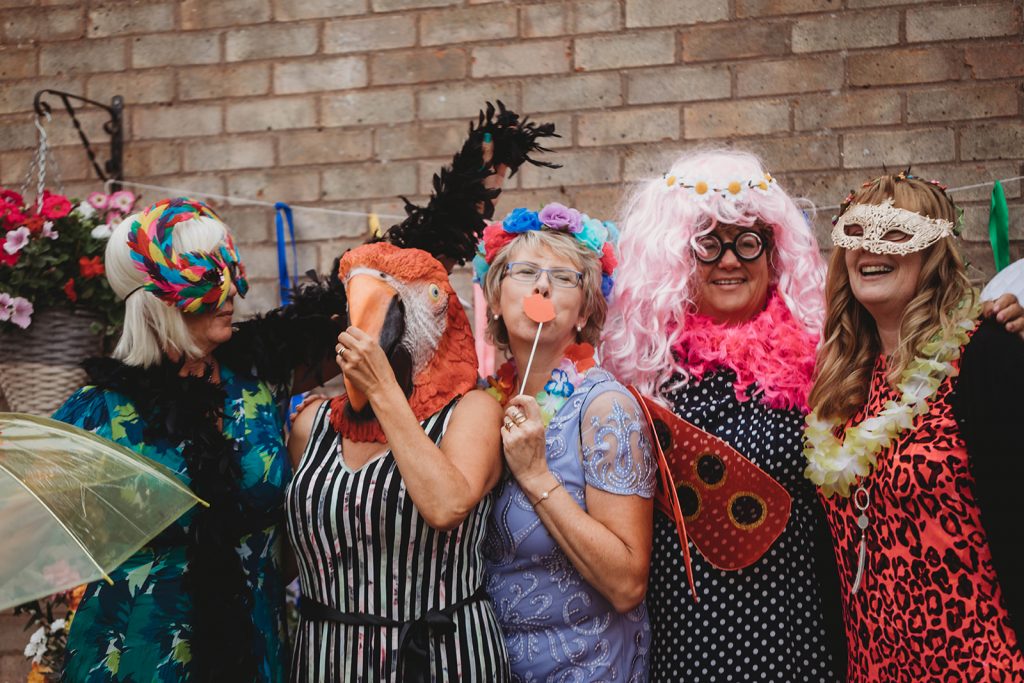 Wedding guests enjoying dressing up and using the DIY garden photo booth
