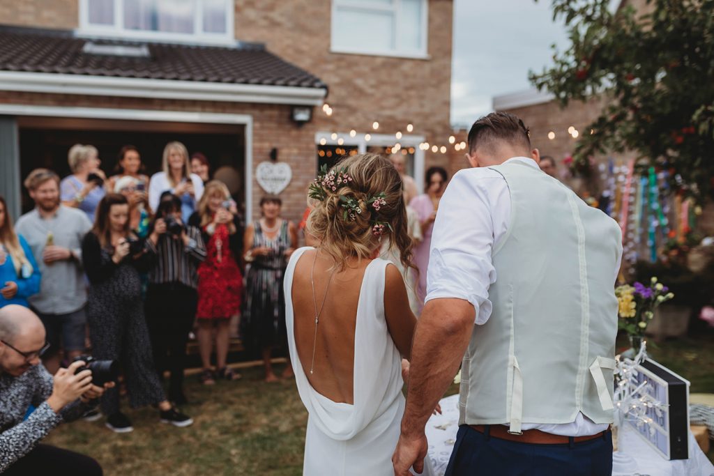 Guests watching the bride and groom cut their wedding cake