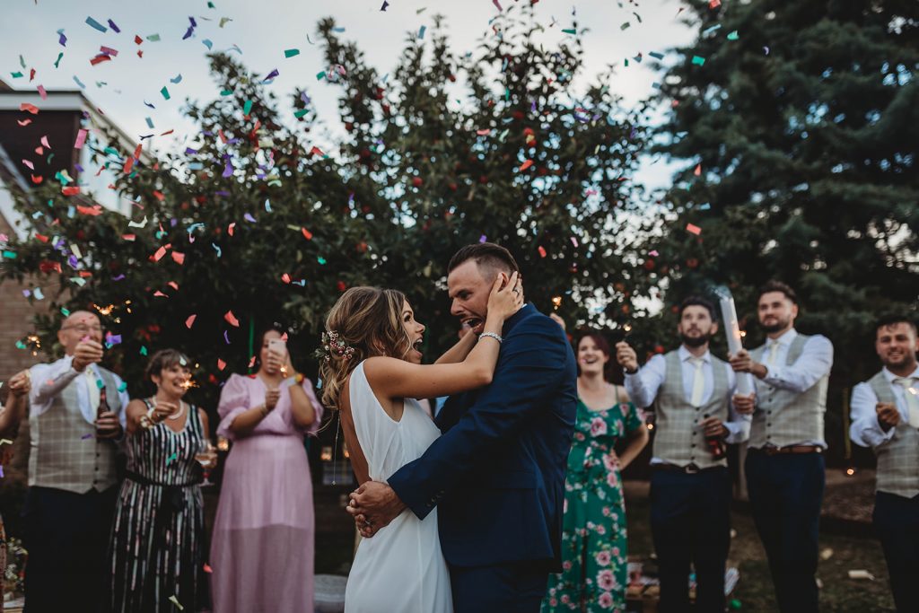 Bride and groom have their first dance on their wedding day whilst being showered with confetti canons