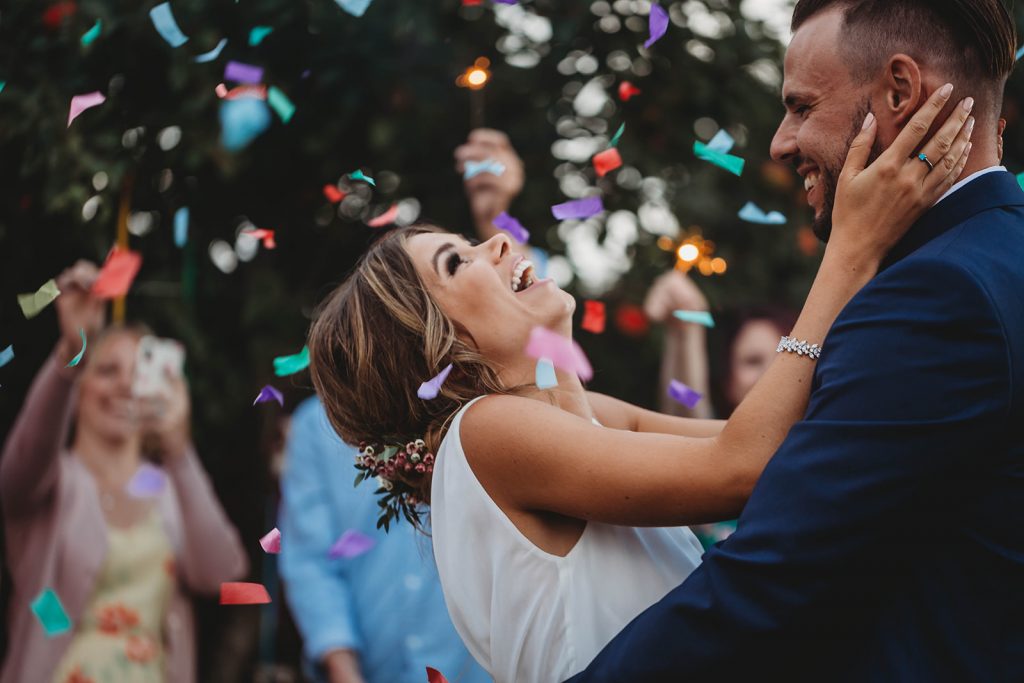 Bride and groom have their first dance on their wedding day whilst being showered with confetti canons