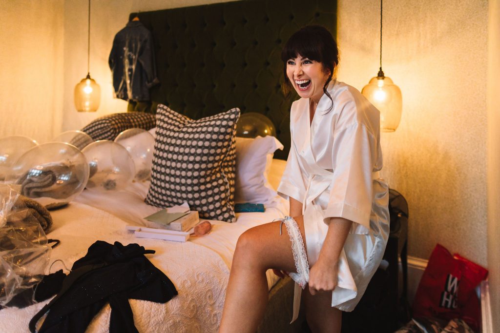 Bride showing off her wedding garter as she gets ready for her wedding day