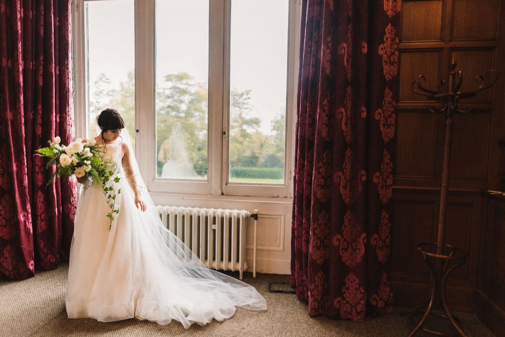 A bride taking a moment on her wedding day as she just finished putting on her wedding dress