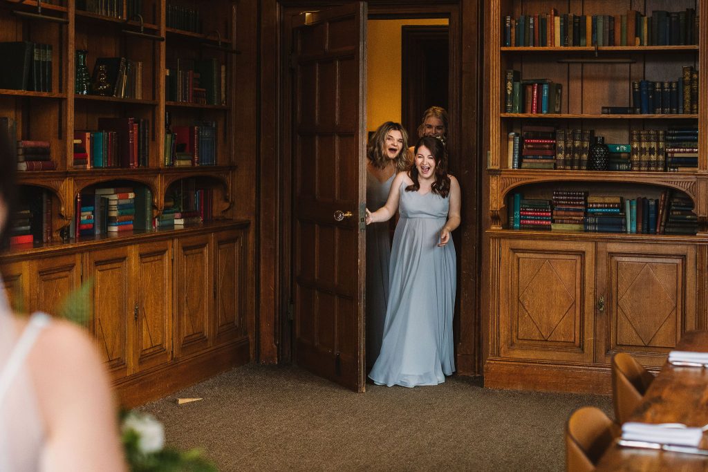 Bridal party about to have the reveal for the Bride's wedding dress