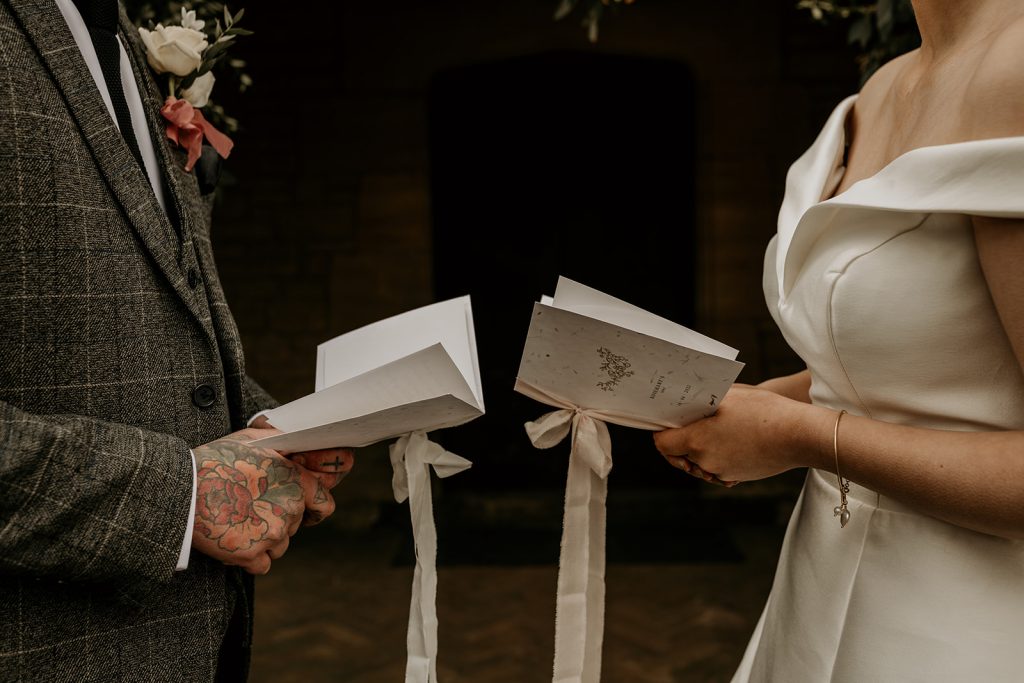 Bride wearing off the shoulder wedding dress exchanging her vows with her soon to be husband