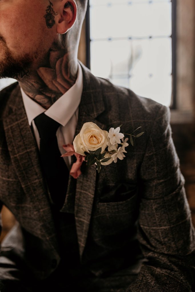 Close up of rustic style button hole for Groom