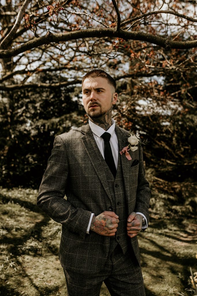 Groom in checked suit with rustic style button hole