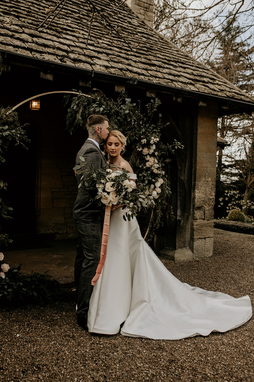 Just married bride and groom in tender embrace during outdoor rustic wedding ceremony