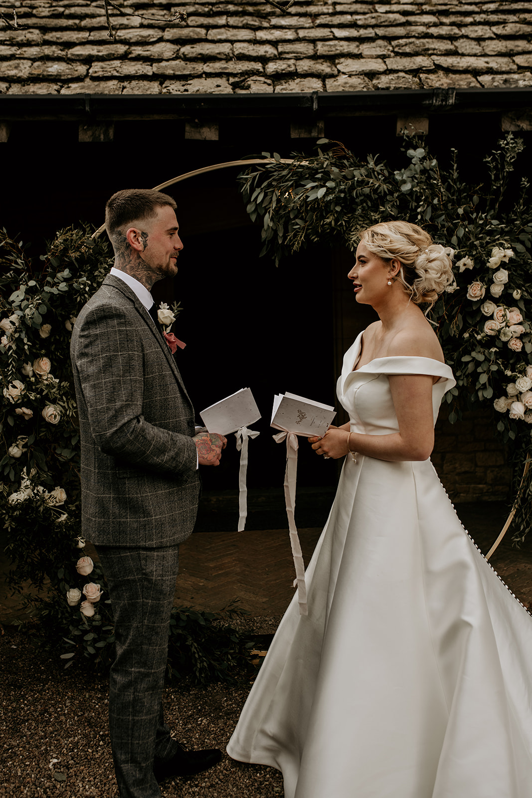 Tattooed bride and groom share their wedding vows during their rustic chic outdoor wedding ceremony