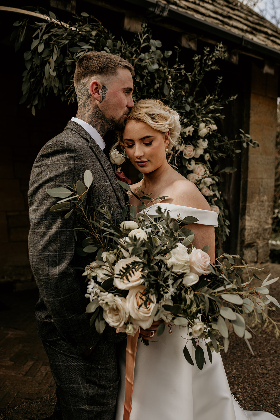 Tattooed bride and groom sharing a tender moment during their civil ceremony