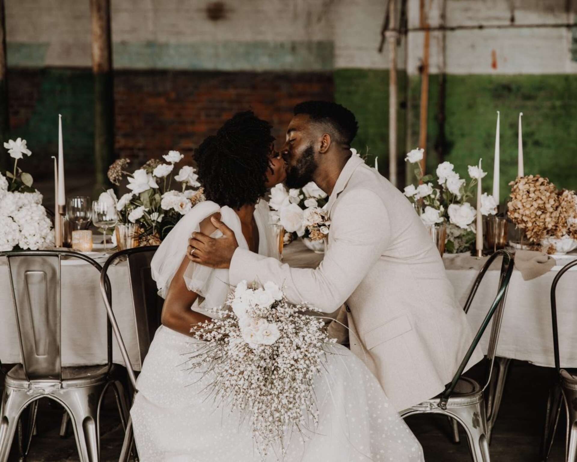 Wedding couple share a kiss, bride is wearing a Berta wedding dress