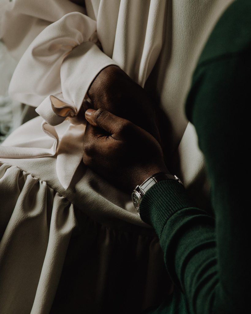 Newlywed bride and groom hold hands tenderly