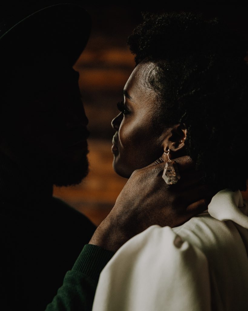 Groom holds his brides face in his hand gently as she gazes at him