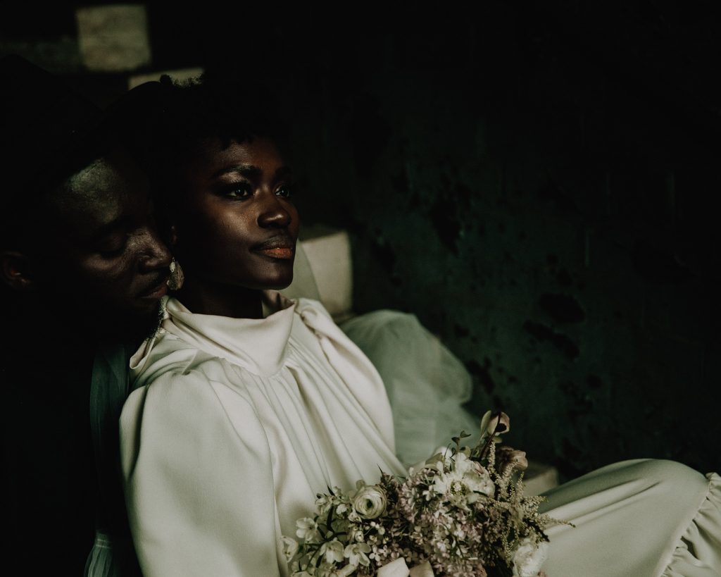 Newly married wedding couple enjoying some quiet time on their micro wedding day. Th ebride wears a high neck Moonchild wedding dress