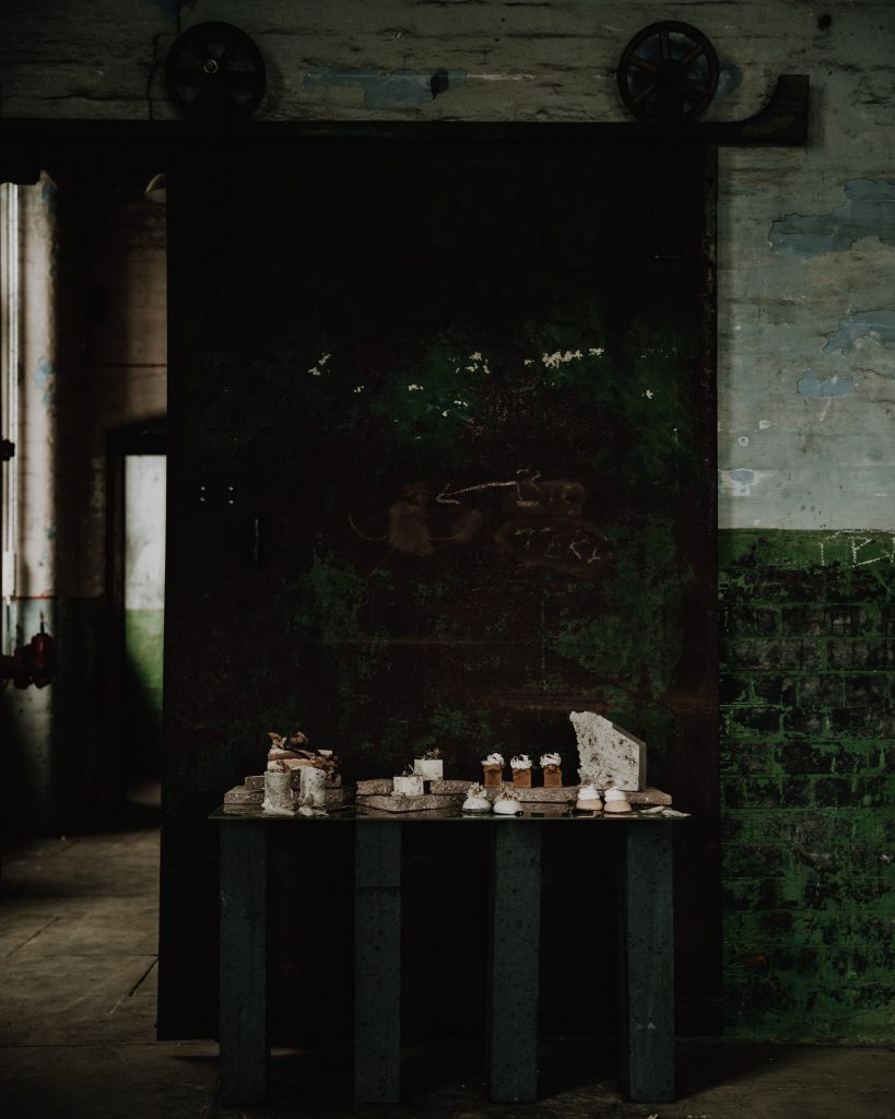 A wedding cake table of earthy tones and muted hues for an industrial micro wedding