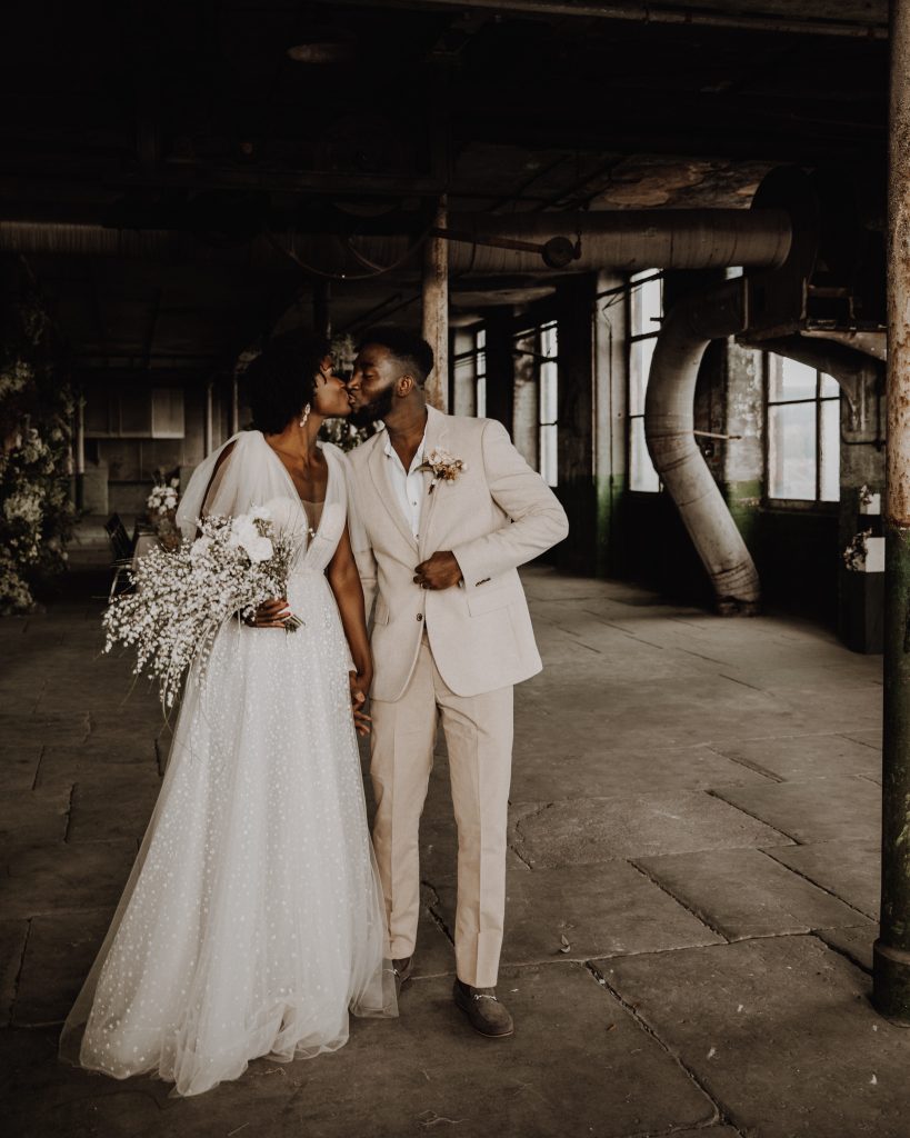 Bride and groom gently kiss whilst standing up on their wedding day at a cool city micro wedding venue