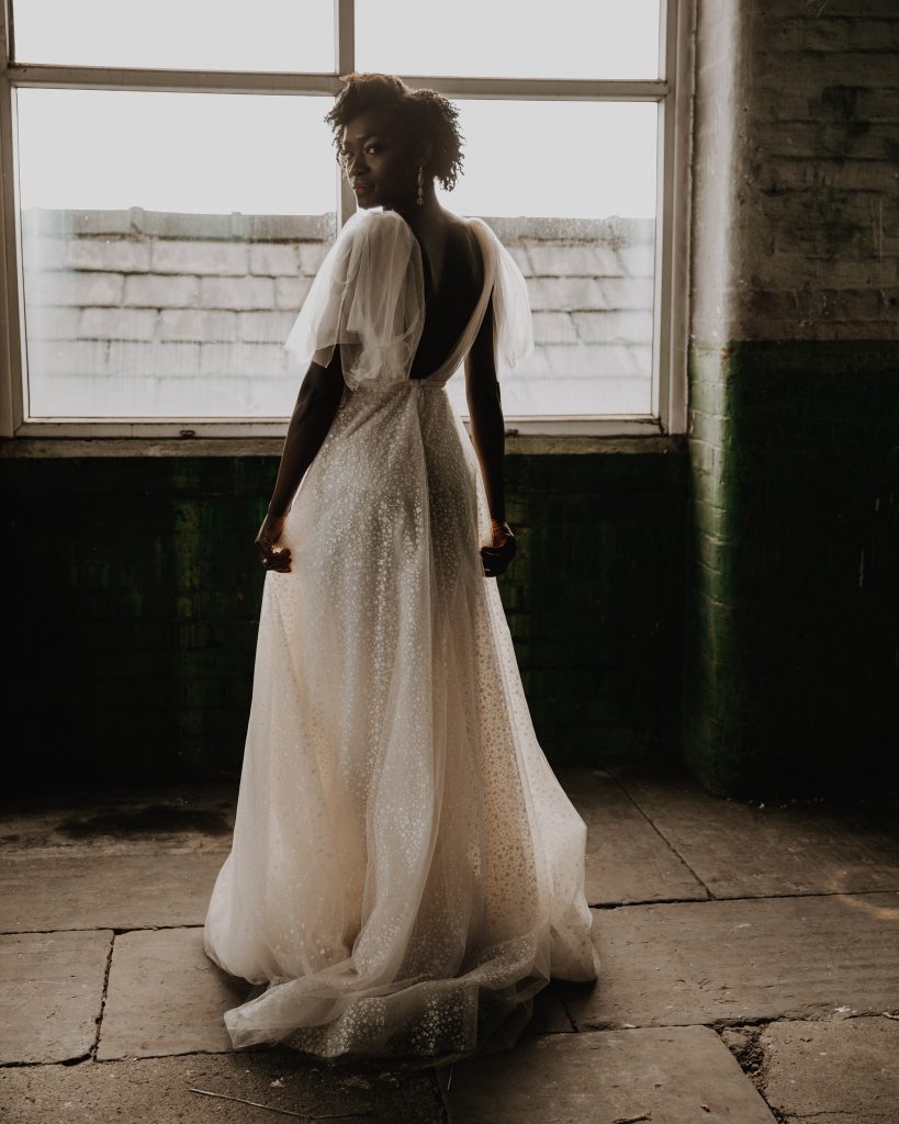 Back image of a wedding gown for a new bride. She wears a flowy sparkling Berta wedding gown