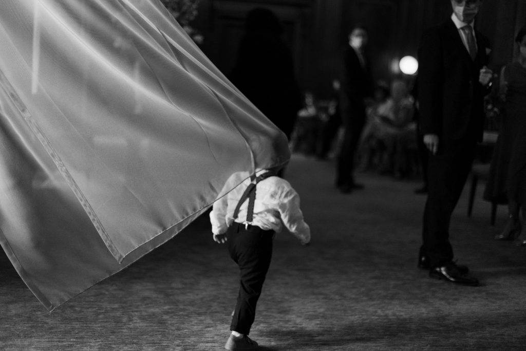 Black and white image of little boy at wedding dressed in braces