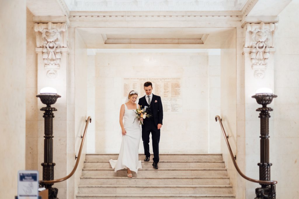 Newlyweds walk down the stairs at the Old Marylebone Town Hall, London as husband and wife