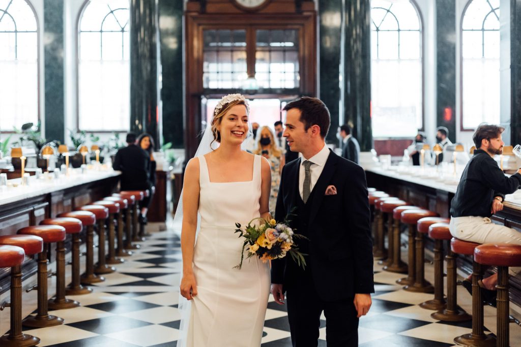 Newly married bride and groom arrive at The Ned in London, their wedding reception venue