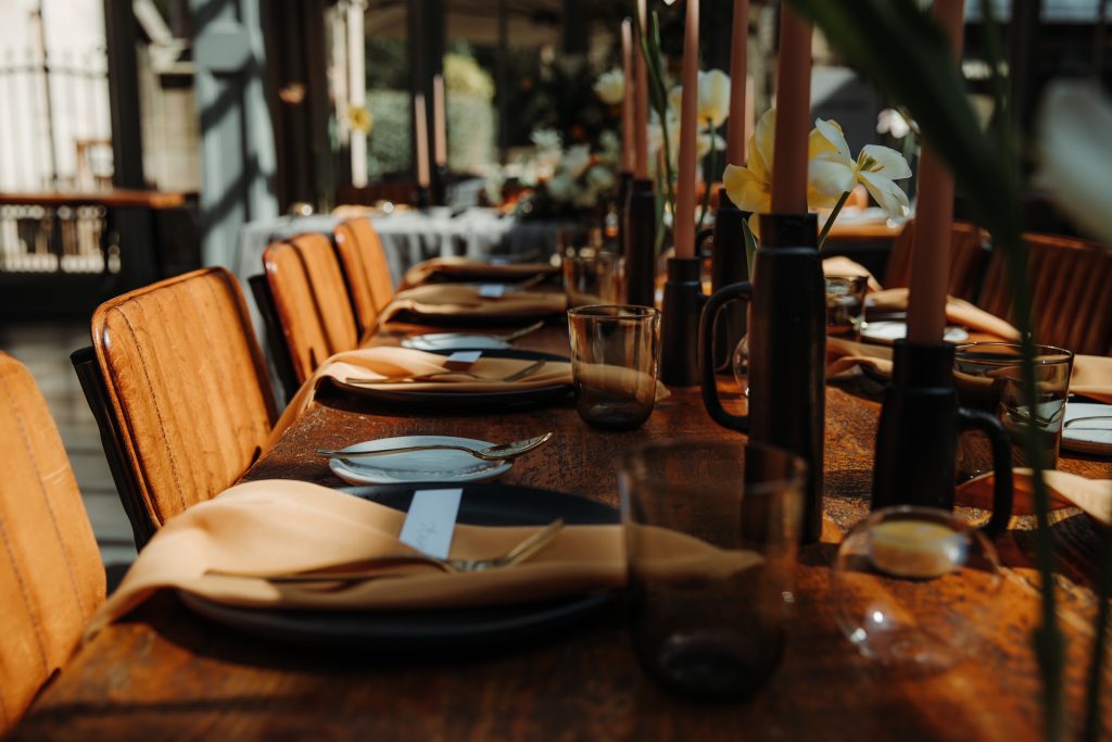 Wooden table wedding styling for spring wedding with colour palette of muted yellows and blacks
