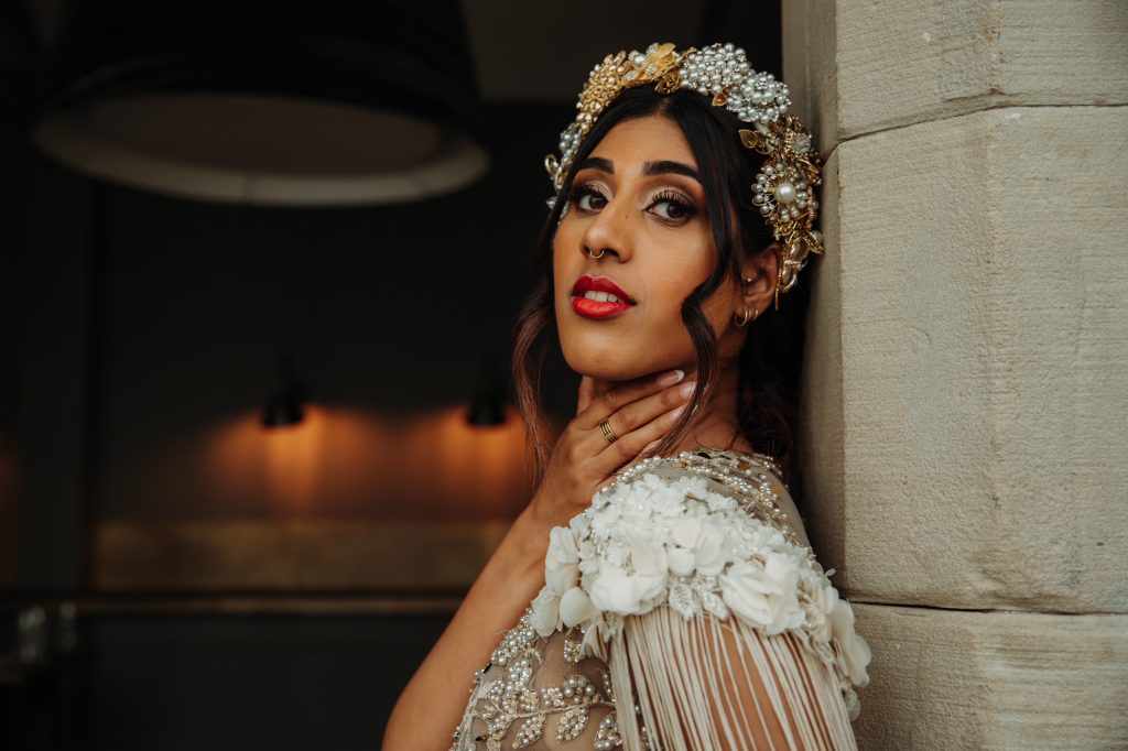 Close up of a beautiful bride's embellished wedding head band with bright red lipstick