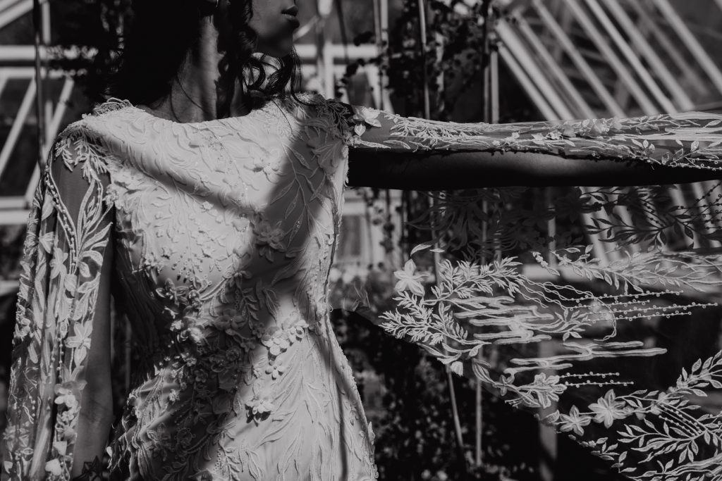 Black and white close up of a beautifully hand embroidered wedding dress with lots of texture