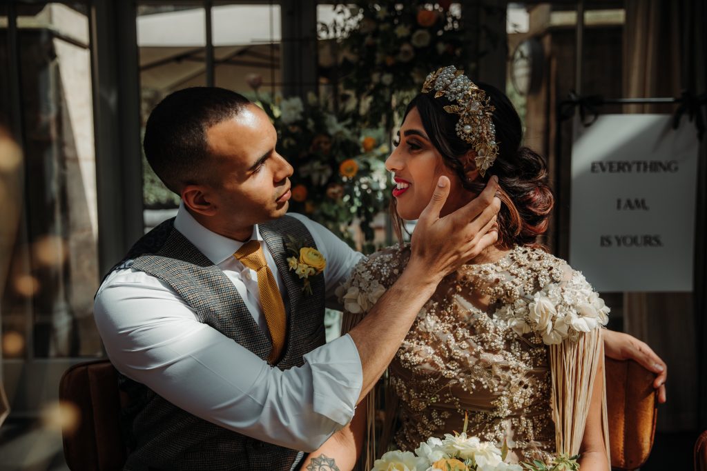A newly married bride and groom. The groom cups his bride's face gently in his hand