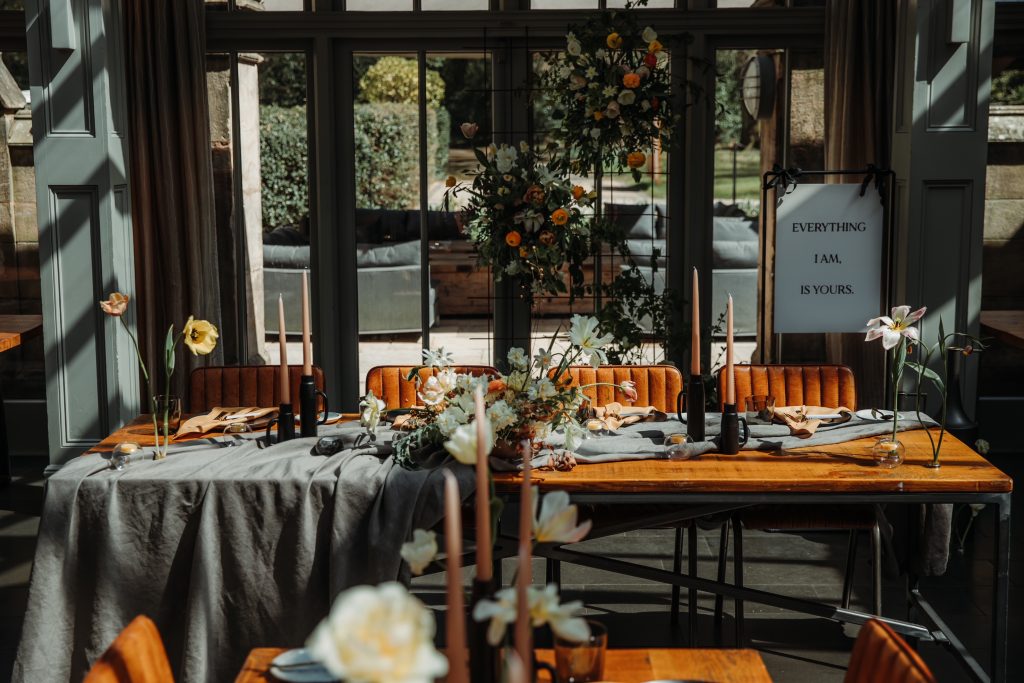 A wedding scene set in a country manor house of draped tables, tulips and greenery