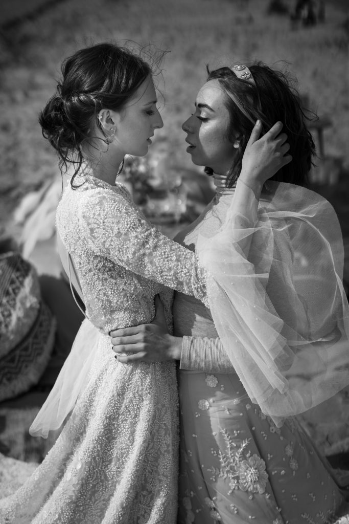 Two newlywed brides in sunset beach wedding elopement