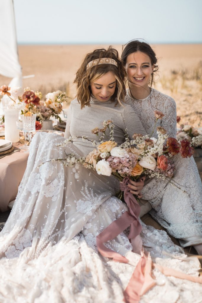 Two newlywed brides in sunset beach wedding elopement