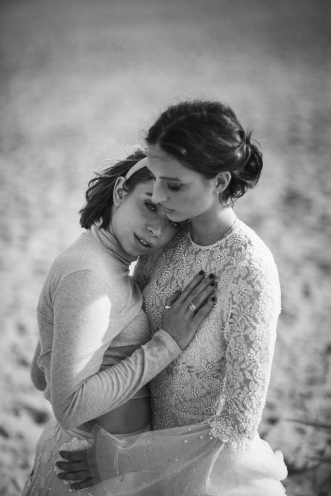 Two newlywed brides in sunset beach wedding elopement