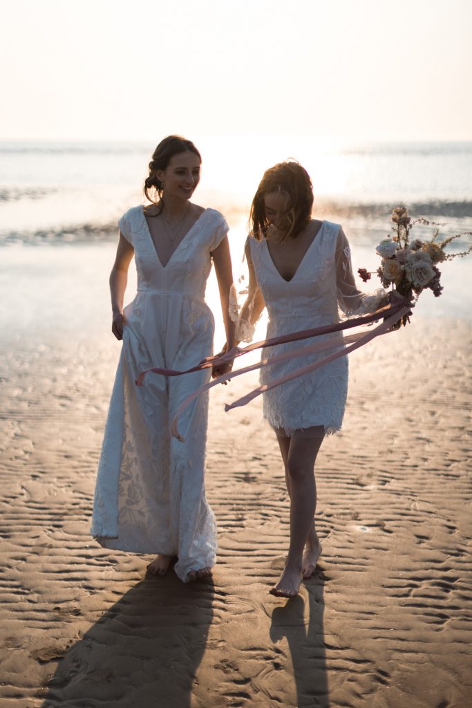 Two newlywed brides in sunset beach wedding elopement