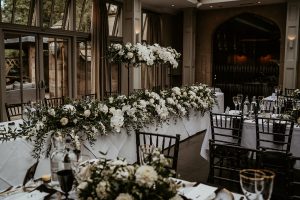 Black and white contemporary wedding table styling with hints of gold and greenery for luxury country house wedding