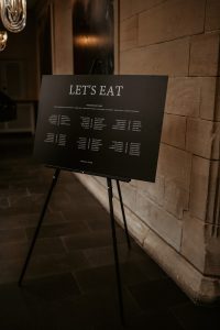 Black minimalist modern table plan with white writing on a black stand