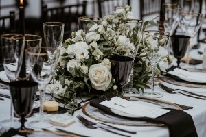 Black and white contemporary wedding table styling with hints of gold and greenery for luxury country house wedding