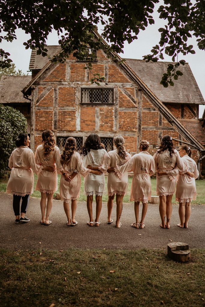 A bride and her bridesmaids wearing bridal robes and posing on the wedding morning during bridal prep
