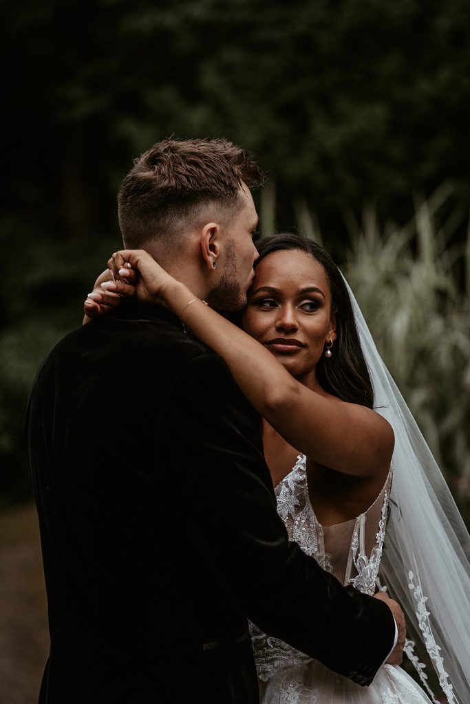 A tender kiss on the forehead from a groom to his new wife on their wedding day