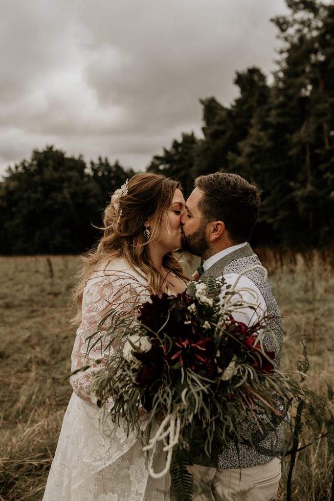 A newlywed bride and groom share a tender wedding day kiss