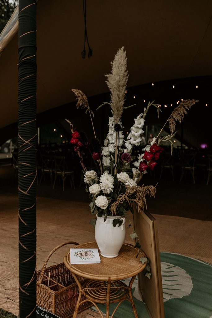 Floral display of greens and whites with pampas grass for outdoor woodland wedding