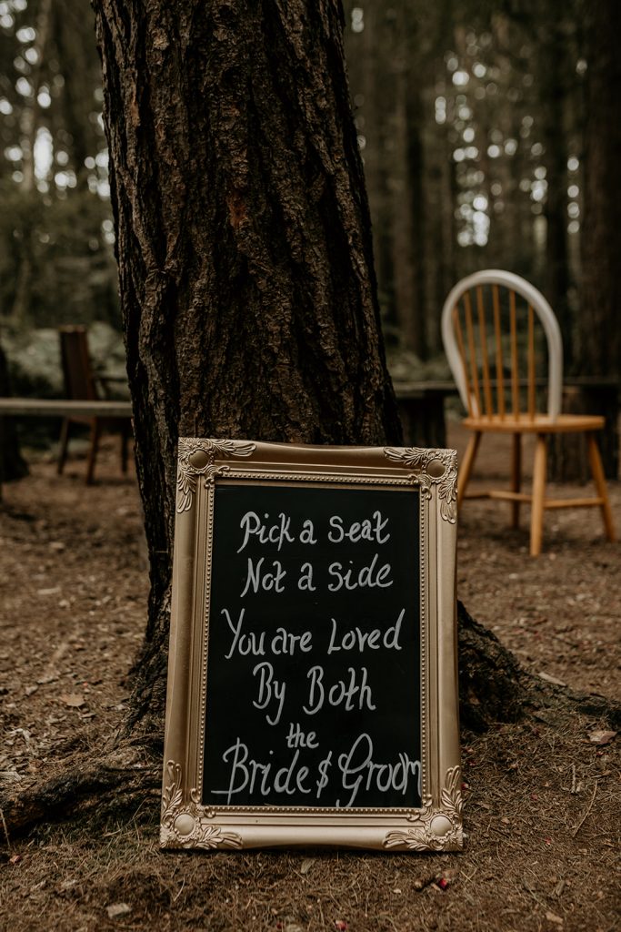 DIY mirror 'Pick a seat not a side' wedding signage for forest ceremony