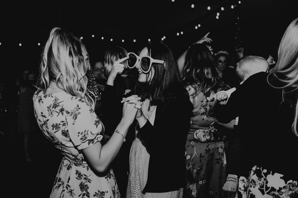 Wedding guests enjoy the fancy dress costume box during evening marquee wedding party