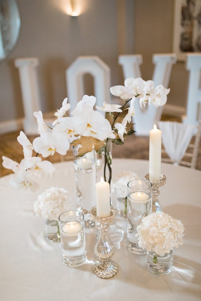 All white dusk wedding reception styling with orchids and candles