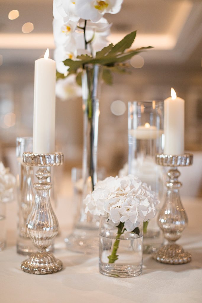 All white dusk wedding reception styling with orchids and candles