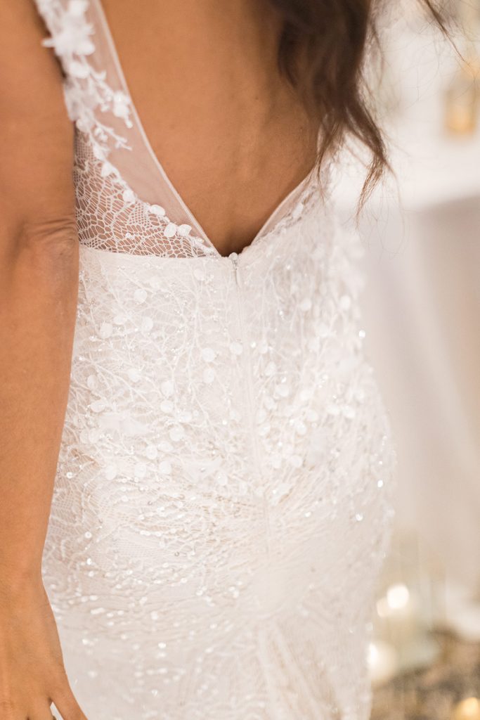 A sparkling and intricately detailed close up of an Inbal Dror wedding dress
