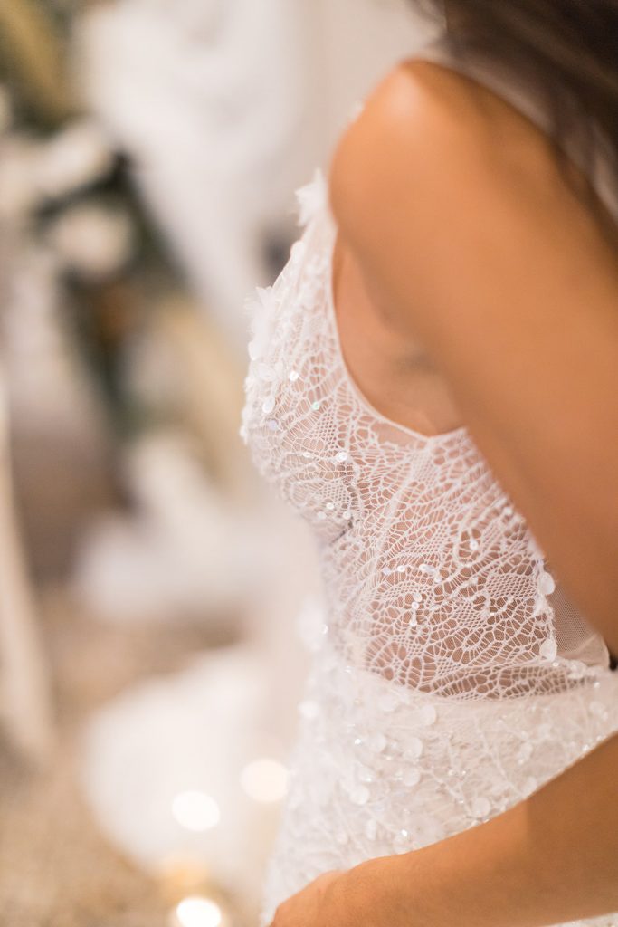 A sparkling and intricately detailed close up of an Inbal Dror wedding dress