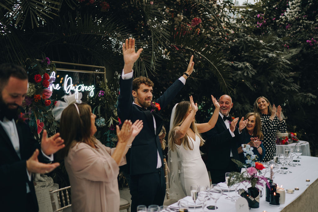 Guests stand and cheer as newlyweds Grace + Elliott take their seats at their top table